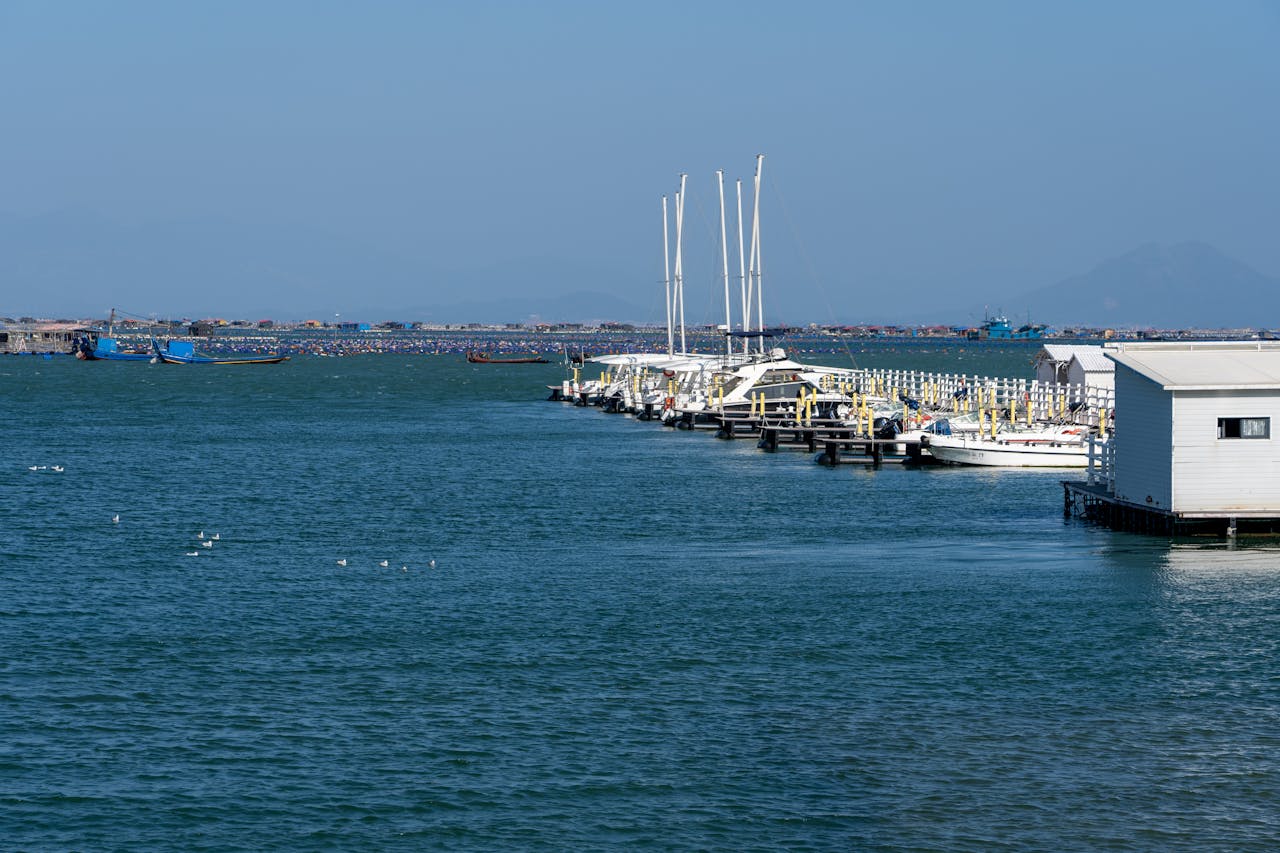 A tranquil view of a marina with boats under a clear sky on a sunny day, perfect for travel inspirations.